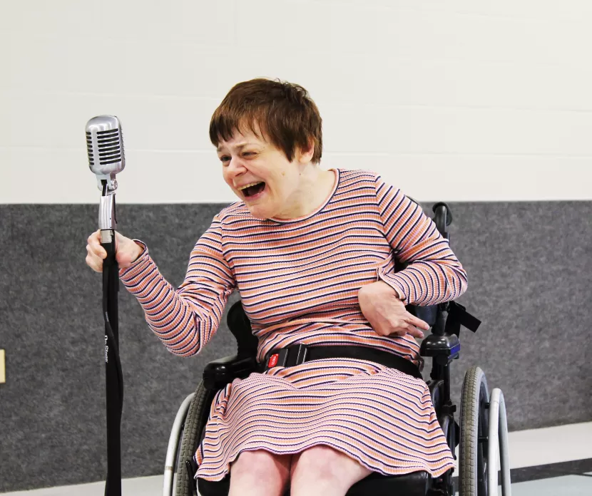 a woman in a wheelchair singing