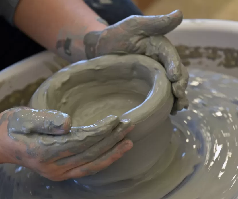  A person shaping clay on a potter's wheel.
