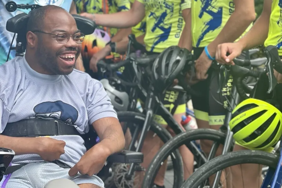 African American man smiling in front of a line of bikers