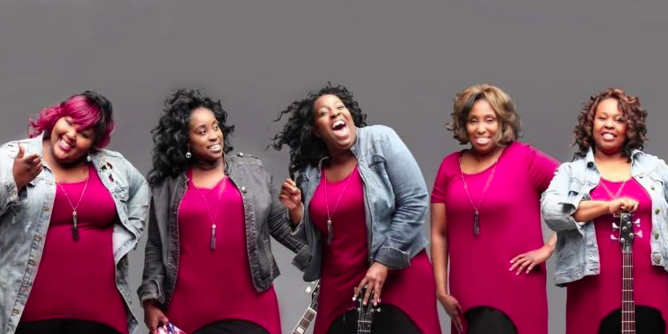Promotional photo of Nikki D and the Sisters of Thunder, a five-member band smiling with guitars, performing at the Sounds of Sunshine Concert Series at Sunshine Communities.