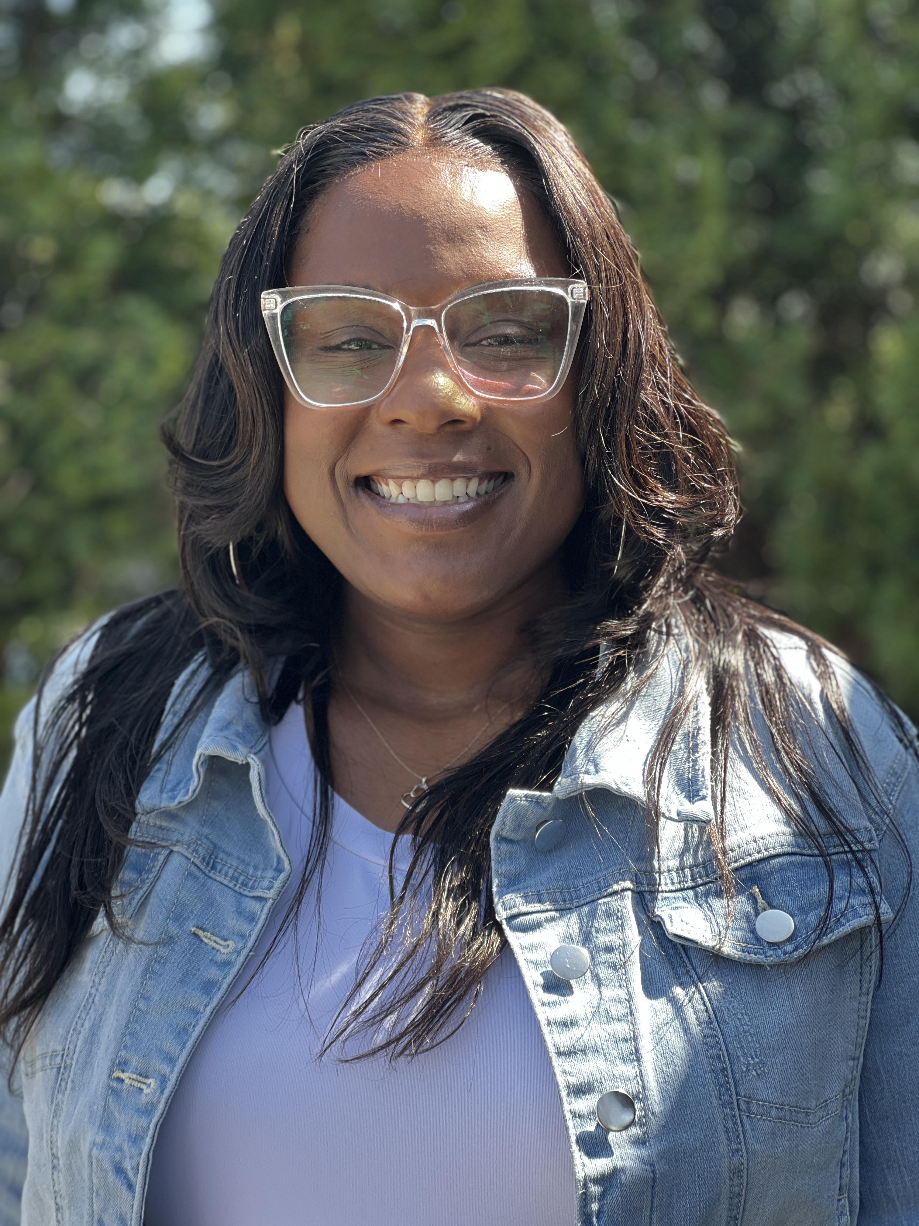 Jasmine Burnley, a Sunshine Communities team member, smiling outdoors d