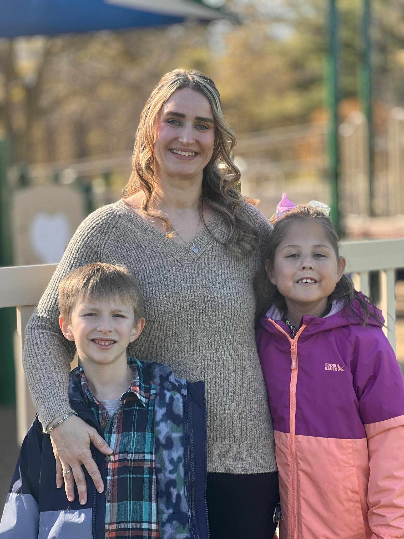 Mother and children smiling at Sunshine Communities playground in Maumee Ohio.