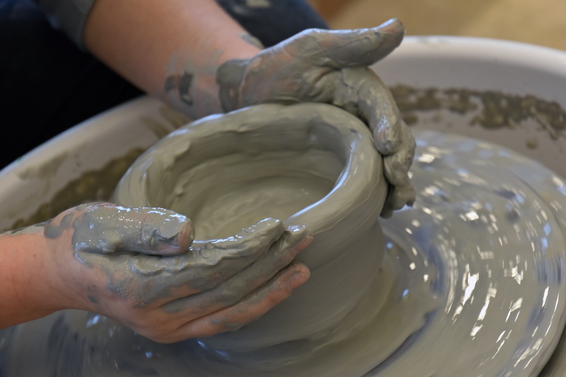  A person shaping clay on a potter's wheel.