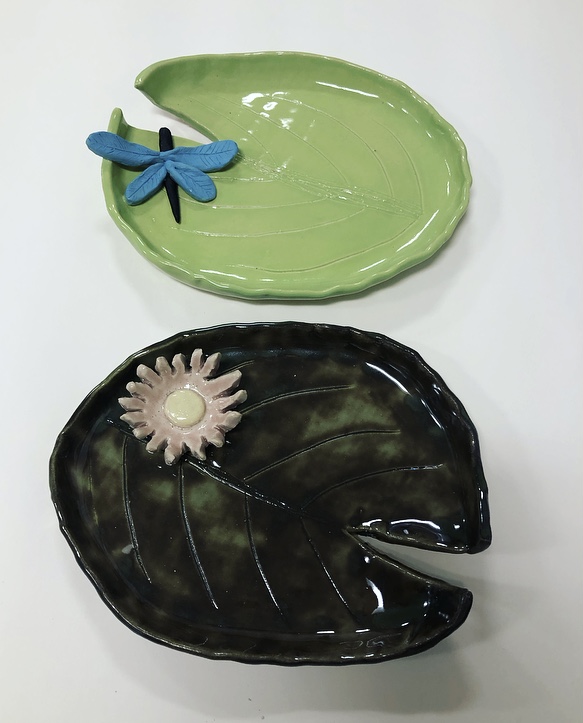  Two ceramic plates featuring a dragonfly and a leaf design