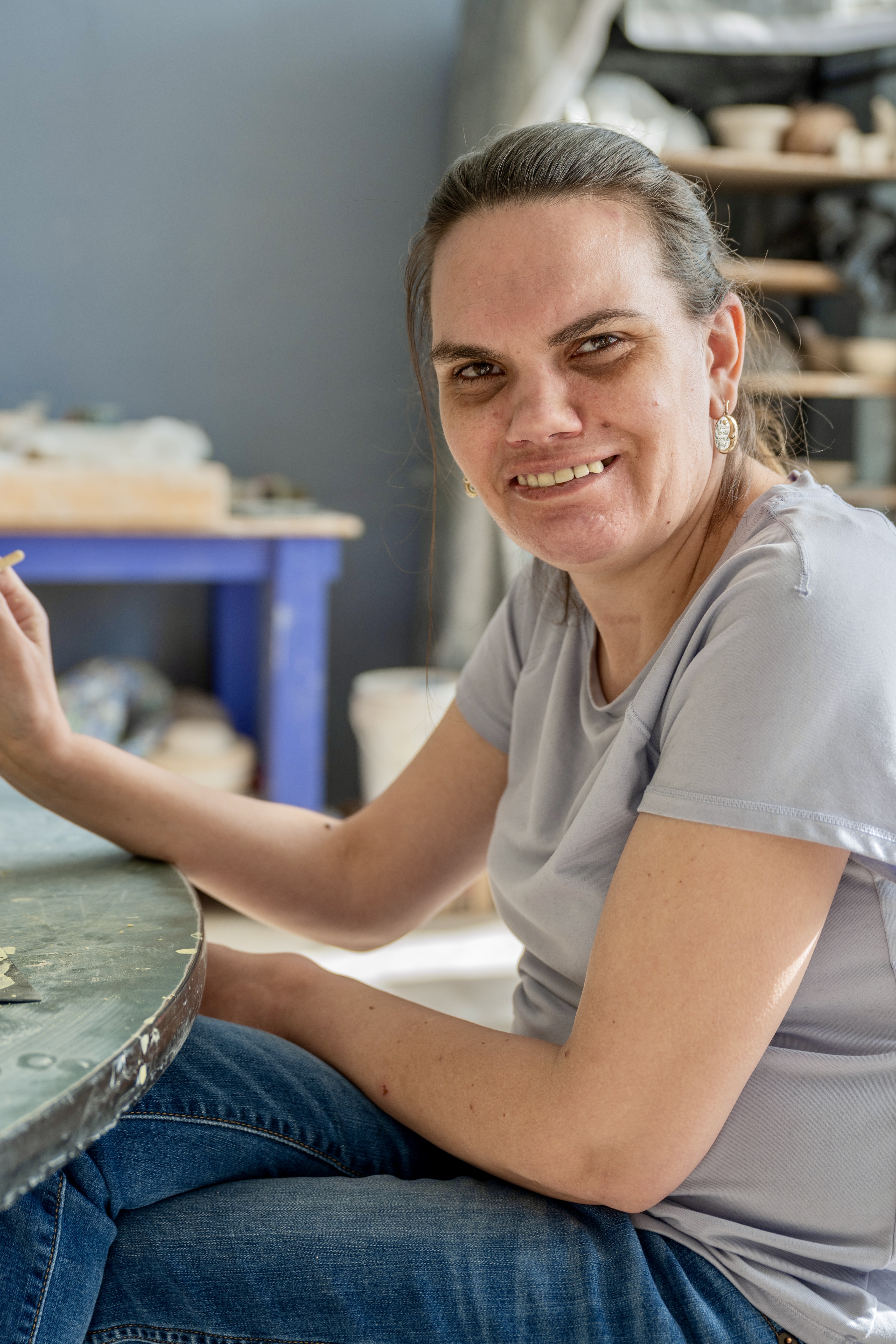 Woman seated at a worktable inside Sunshine Studios.