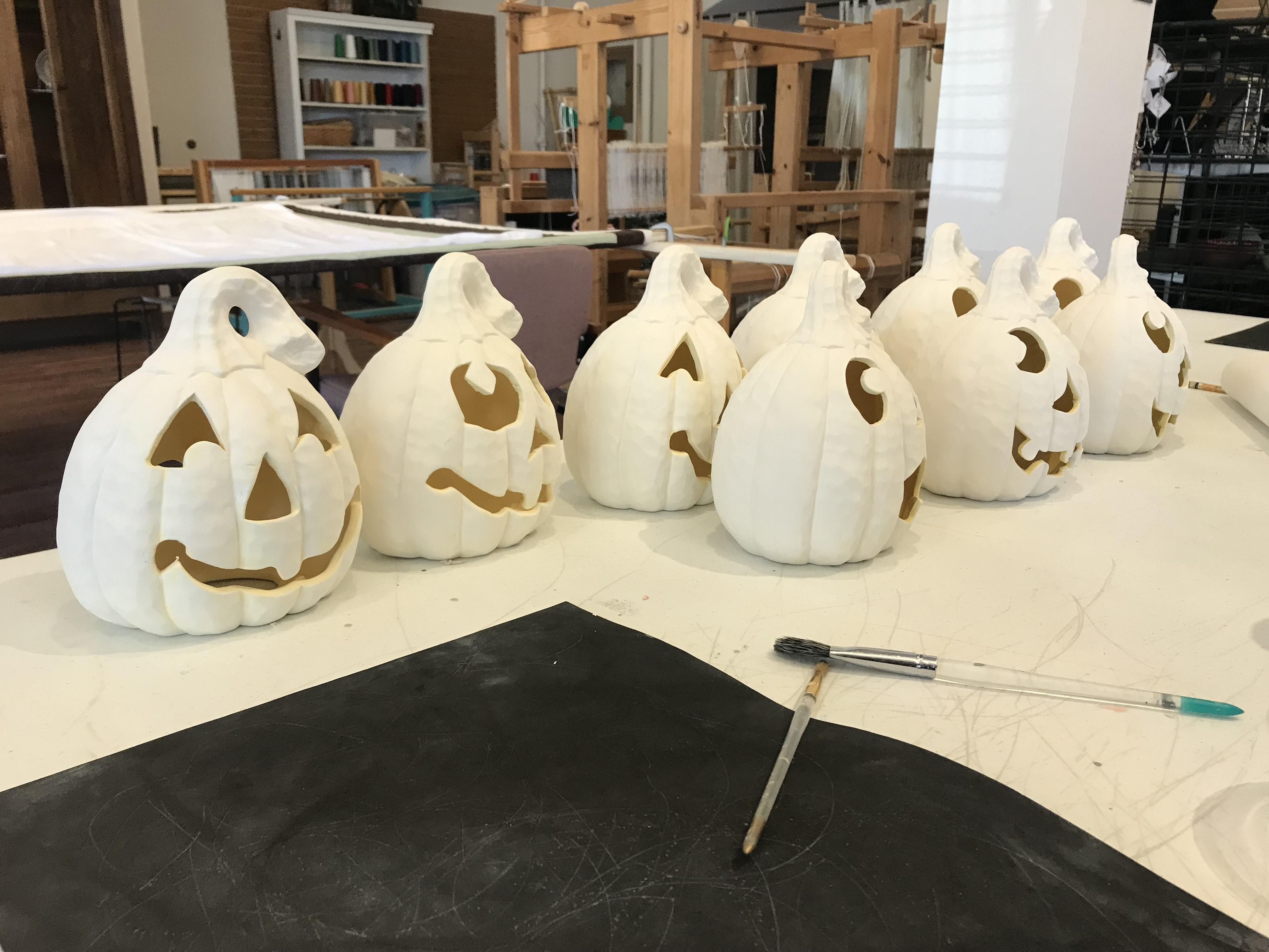 A collection of white pumpkins arranged neatly on a wooden table, showcasing their smooth, pale surfaces.