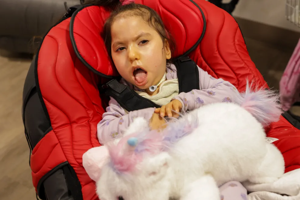 ela laying in her bed with a stuffed animal
