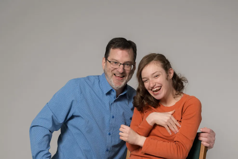 Phil Skeldon and Lily Skeldon smiling together during a studio portrait session, highlighting family connection, support, and community engagement.