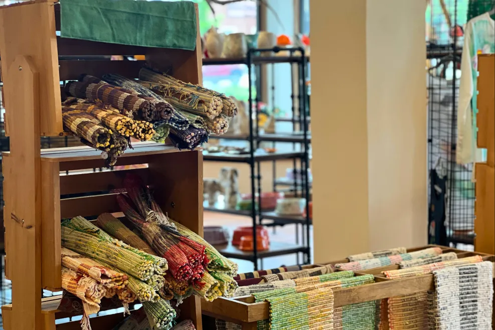 Display of colorful handwoven rugs and artisan textiles available for purchase at Sunshine Studios in Maumee, Ohio.