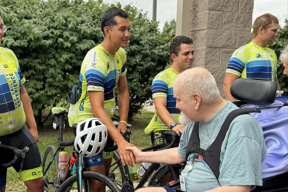 Journey of Hope cyclist shaking hands with a Sunshine Communities resident.