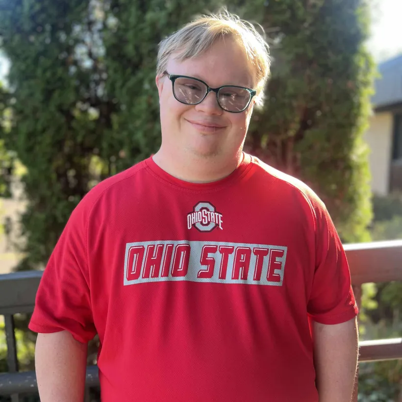 Smiling Sunshine Communities participant wearing an Ohio State shirt outdoors in Northwest Ohio.