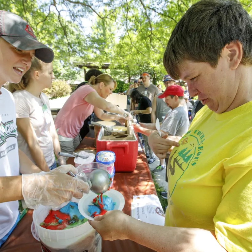 People enjoying ice cream at an outdoor community event celebrating inclusion and developmental disabilities awareness.