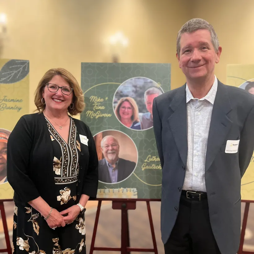 Mike & Trina McGivern, standing in front of sign at awards dinner